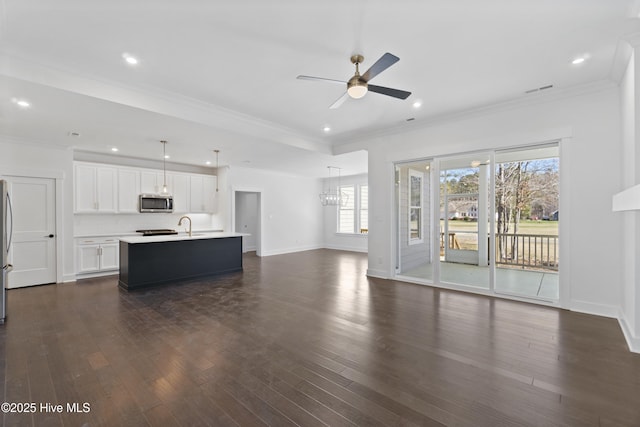 unfurnished living room featuring ceiling fan, ornamental molding, and dark hardwood / wood-style floors