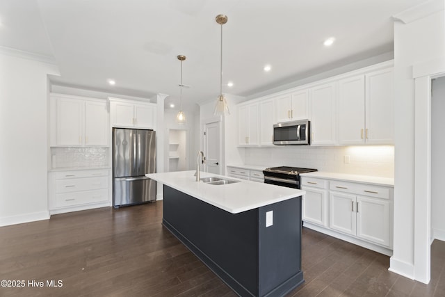 kitchen with white cabinets, decorative light fixtures, stainless steel appliances, sink, and a center island with sink