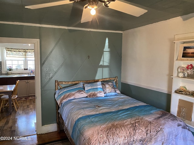 bedroom featuring ceiling fan, dark wood-type flooring, sink, and crown molding