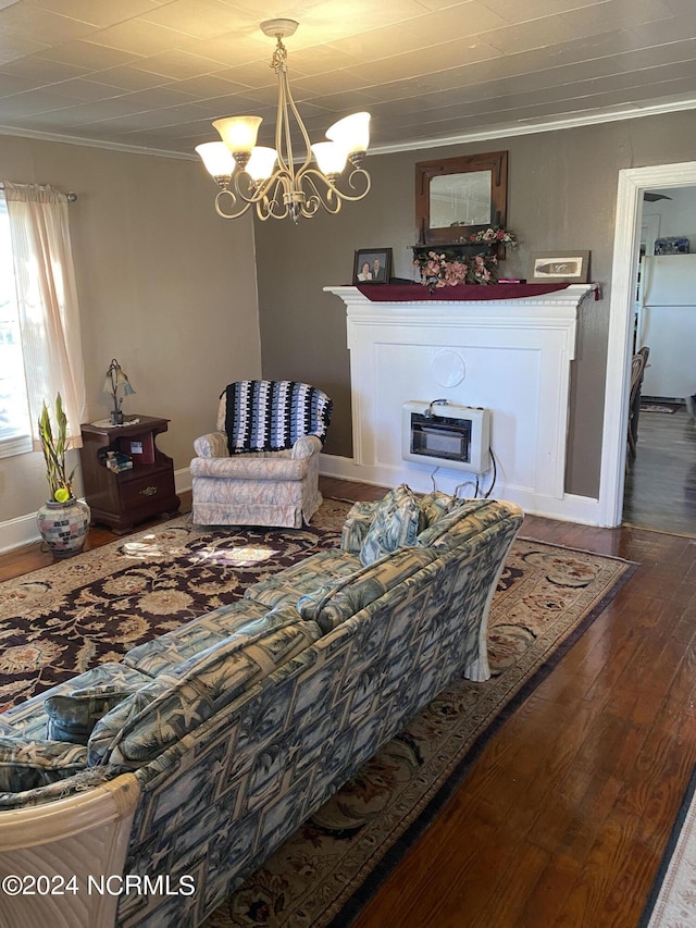 living room featuring an inviting chandelier, ornamental molding, heating unit, and dark hardwood / wood-style floors