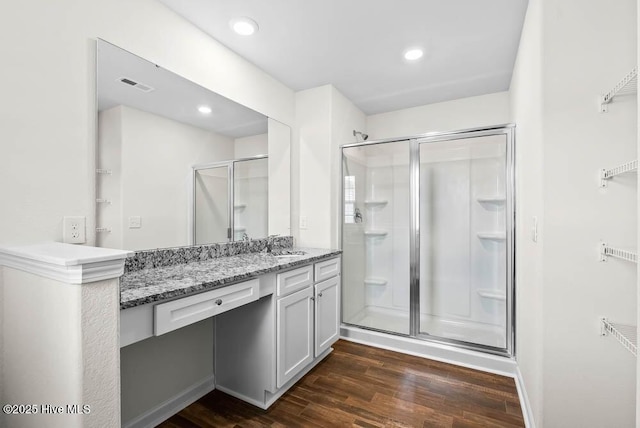 bathroom featuring vanity, wood-type flooring, and a shower with door