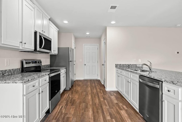 kitchen featuring appliances with stainless steel finishes, dark hardwood / wood-style floors, light stone countertops, white cabinets, and sink