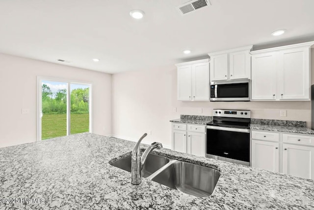 kitchen featuring light stone countertops, sink, white cabinetry, and stainless steel appliances