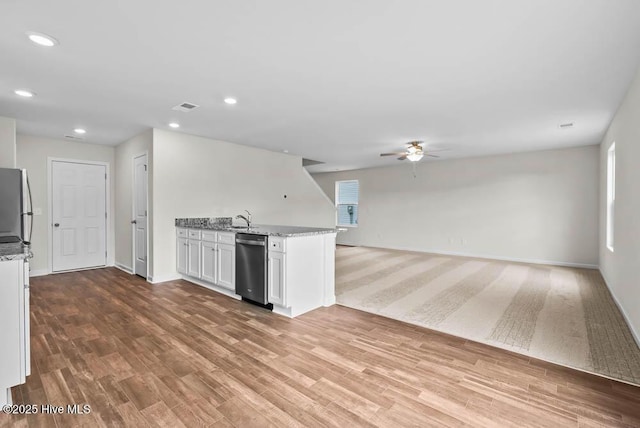 kitchen featuring ceiling fan, light wood-type flooring, white cabinets, light stone counters, and sink