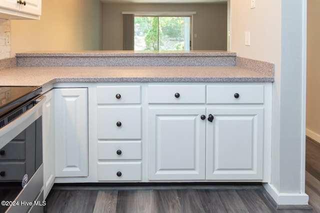 kitchen featuring dark hardwood / wood-style flooring, stainless steel range with electric cooktop, and white cabinetry