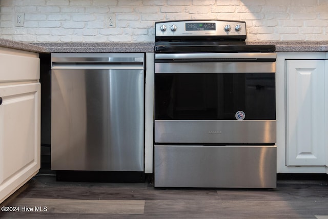 kitchen featuring dark wood-type flooring, appliances with stainless steel finishes, and white cabinets