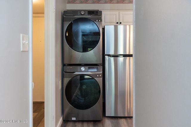 clothes washing area with stacked washer / drying machine and dark hardwood / wood-style flooring