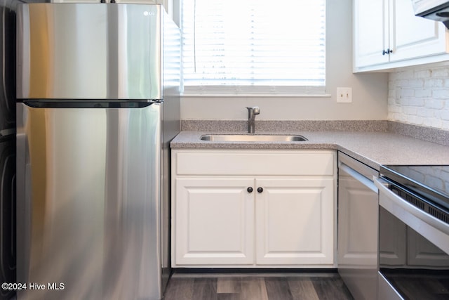 kitchen with white cabinetry, stainless steel appliances, tasteful backsplash, sink, and dark hardwood / wood-style floors