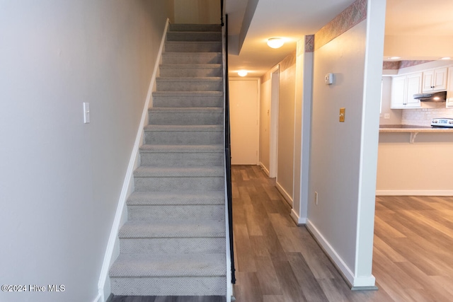 staircase with hardwood / wood-style flooring