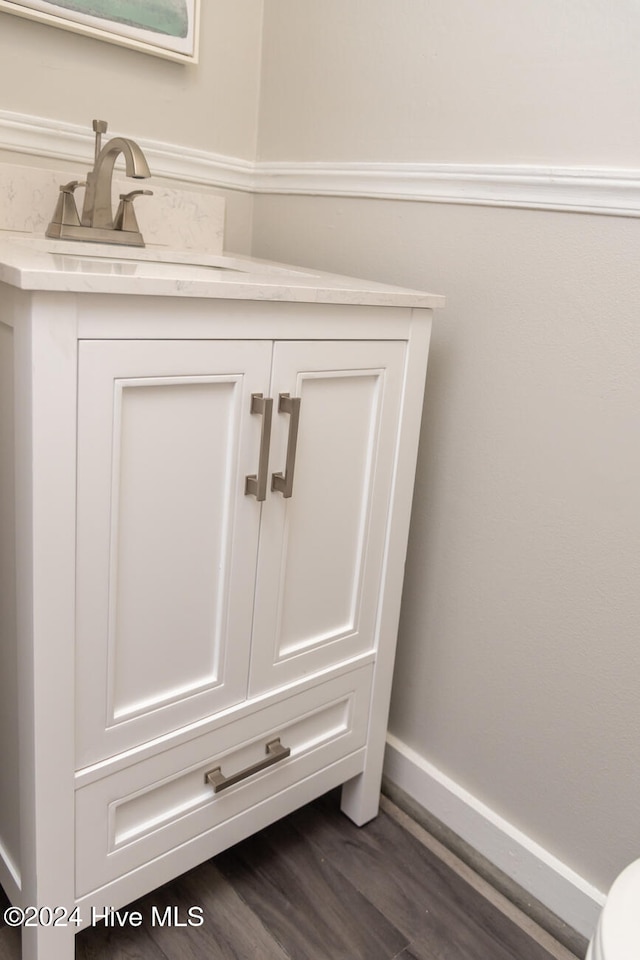 details with vanity and hardwood / wood-style flooring