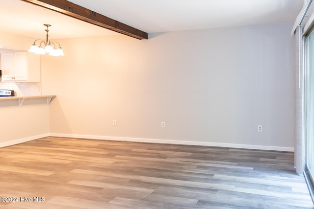 interior space with hardwood / wood-style floors, beam ceiling, and a notable chandelier