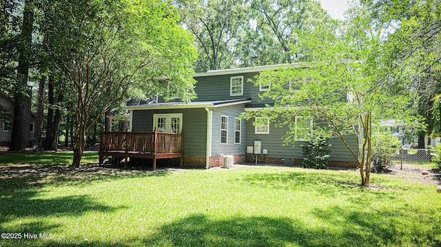 rear view of property with central AC unit, a wooden deck, french doors, and a yard