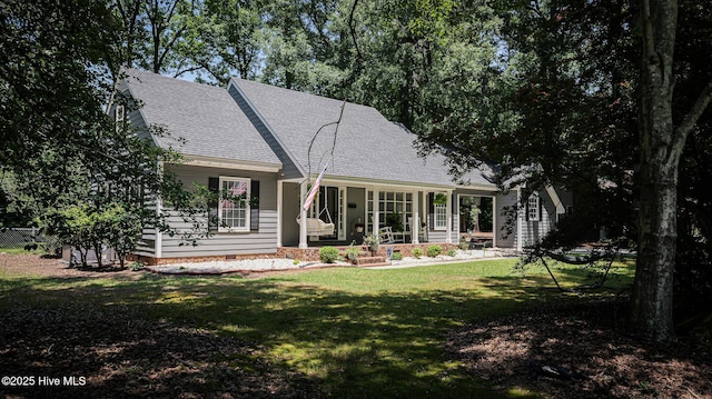 rear view of property with covered porch and a yard