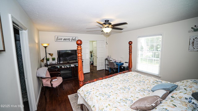 bedroom with dark wood-type flooring, ceiling fan, and a textured ceiling