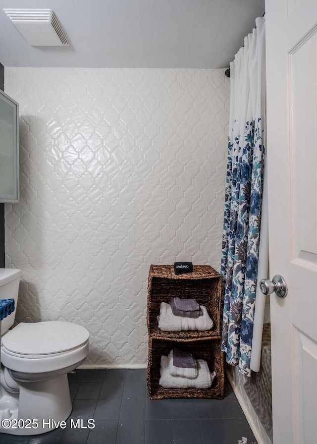 bathroom featuring toilet and tile patterned flooring