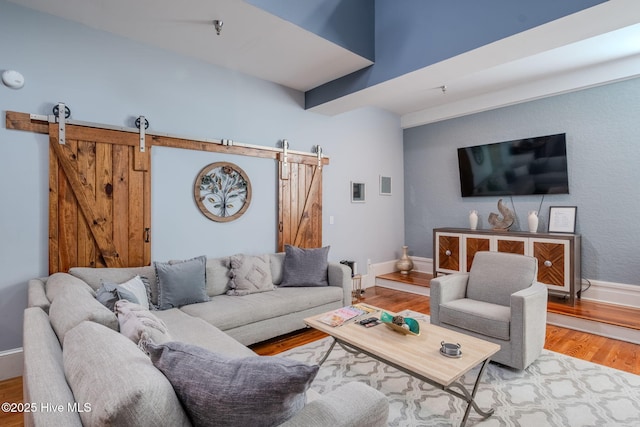 living room featuring a barn door and hardwood / wood-style flooring