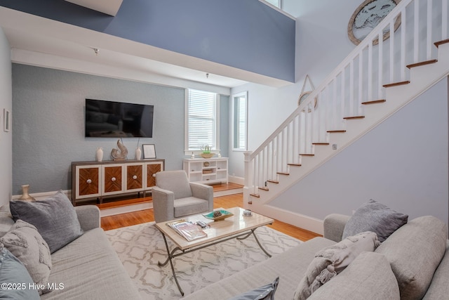 living room with hardwood / wood-style flooring and a high ceiling