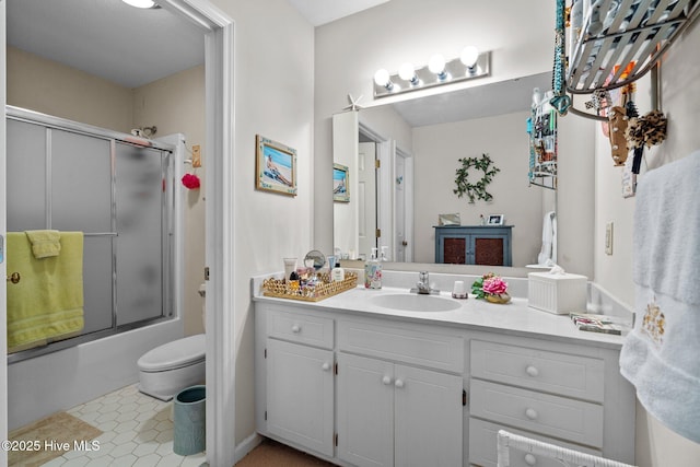 full bathroom with toilet, bath / shower combo with glass door, tile patterned floors, and vanity