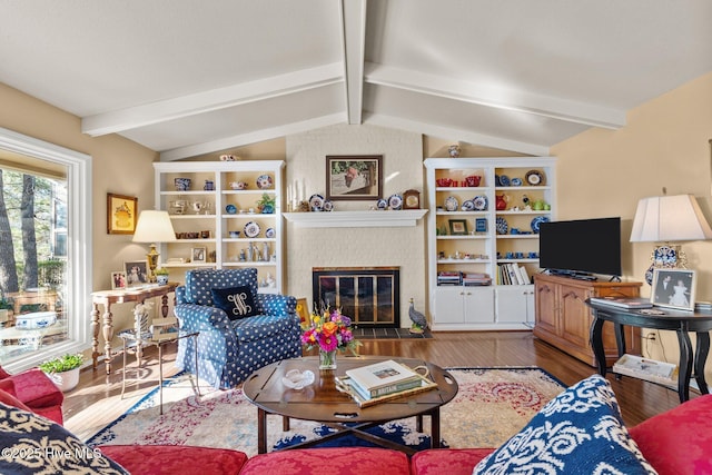 living room with a brick fireplace, hardwood / wood-style floors, and vaulted ceiling with beams