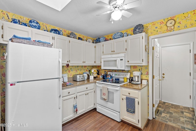 kitchen featuring ceiling fan, white appliances, white cabinets, and a textured ceiling