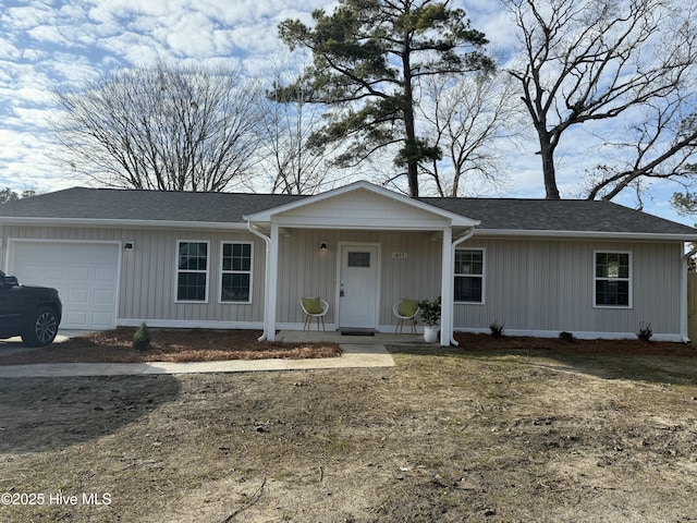 single story home featuring a garage, a front yard, and covered porch