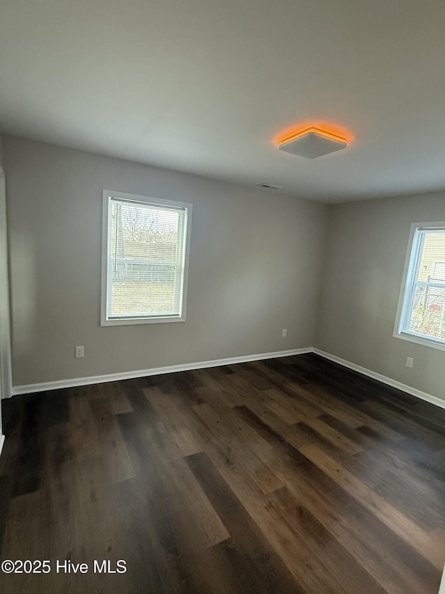 empty room with dark hardwood / wood-style flooring