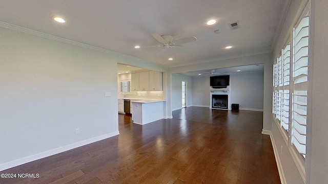 unfurnished living room with ceiling fan, dark hardwood / wood-style floors, and ornamental molding