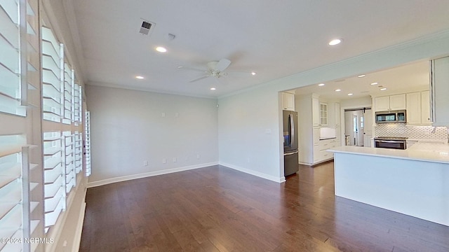 unfurnished living room with ceiling fan, dark hardwood / wood-style floors, ornamental molding, and a healthy amount of sunlight