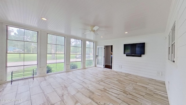 unfurnished sunroom featuring ceiling fan