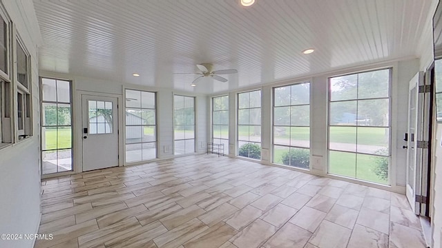 unfurnished sunroom featuring ceiling fan and a healthy amount of sunlight