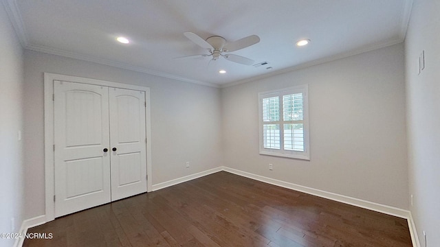 unfurnished bedroom with ceiling fan, a closet, dark wood-type flooring, and ornamental molding