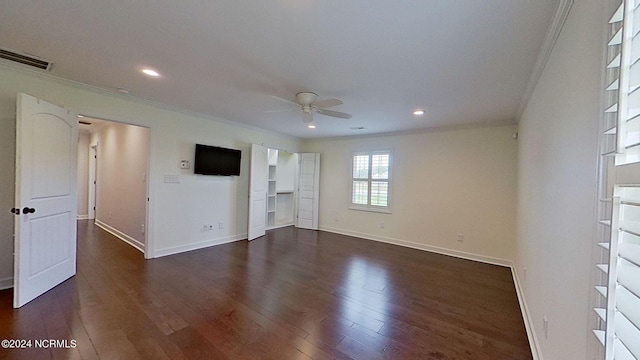 empty room with ceiling fan, dark wood-type flooring, and ornamental molding