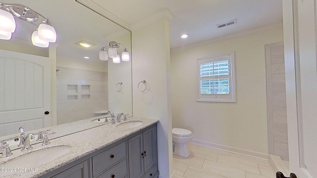 bathroom featuring toilet, vanity, tile patterned flooring, tiled shower, and ornamental molding