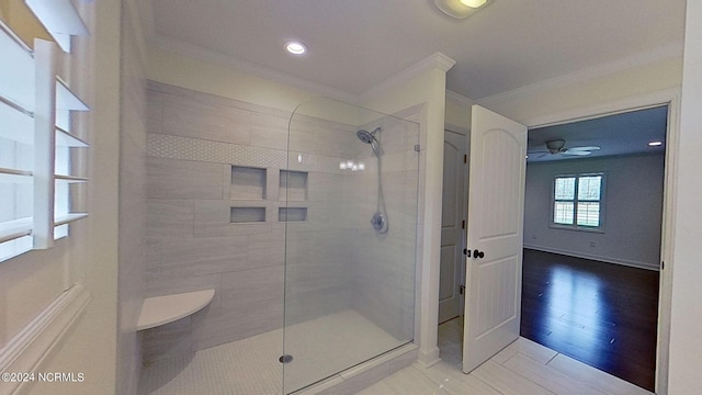 bathroom with tile patterned floors, crown molding, and tiled shower