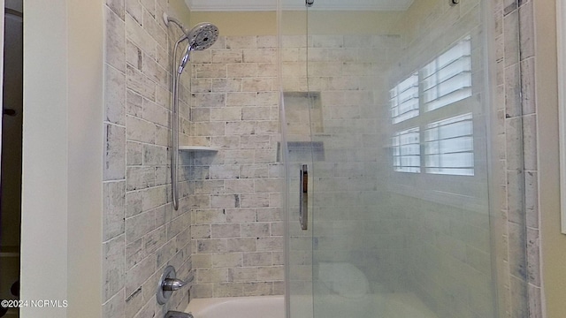 bathroom featuring shower / bath combination with glass door and crown molding