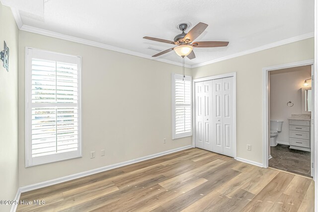 kitchen with white cabinets, hanging light fixtures, light stone counters, stainless steel dishwasher, and light hardwood / wood-style flooring