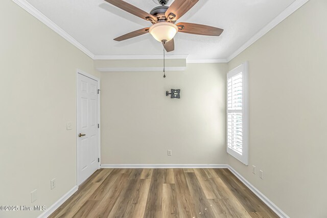 unfurnished bedroom featuring ceiling fan, wood-type flooring, ensuite bathroom, and crown molding