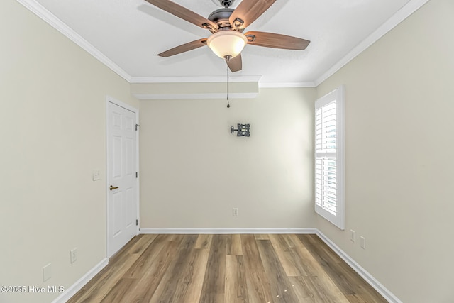 empty room featuring ceiling fan, wood-type flooring, and ornamental molding