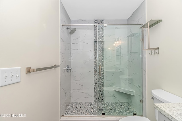 bathroom with toilet, vanity, and a tile shower