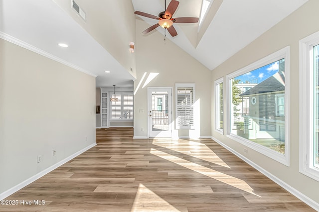 unfurnished living room featuring light wood-type flooring, ceiling fan, and high vaulted ceiling