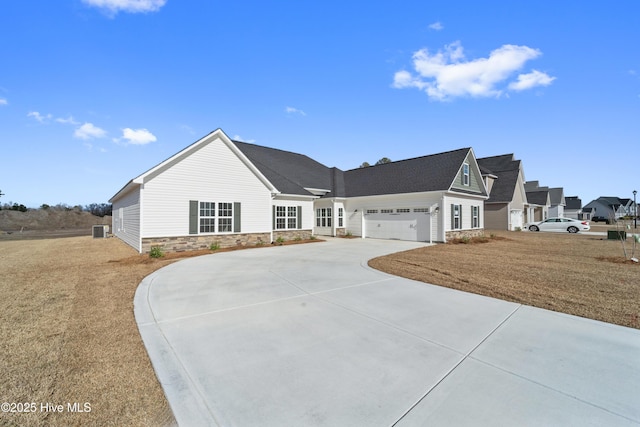 view of front facade with a garage, stone siding, and driveway