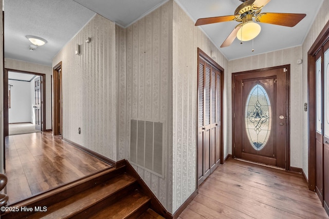 foyer with ceiling fan and light hardwood / wood-style flooring