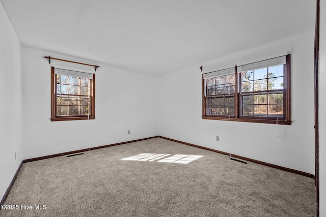 unfurnished room with light colored carpet and plenty of natural light