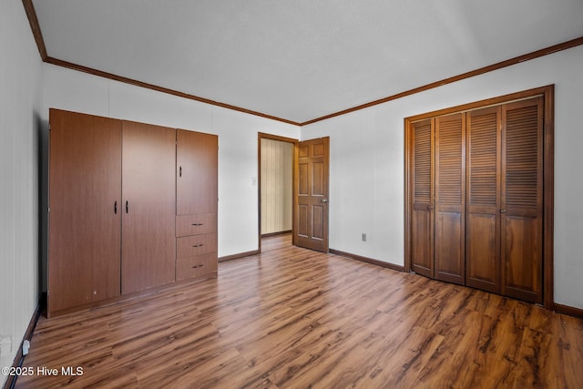 unfurnished bedroom featuring ornamental molding and hardwood / wood-style floors