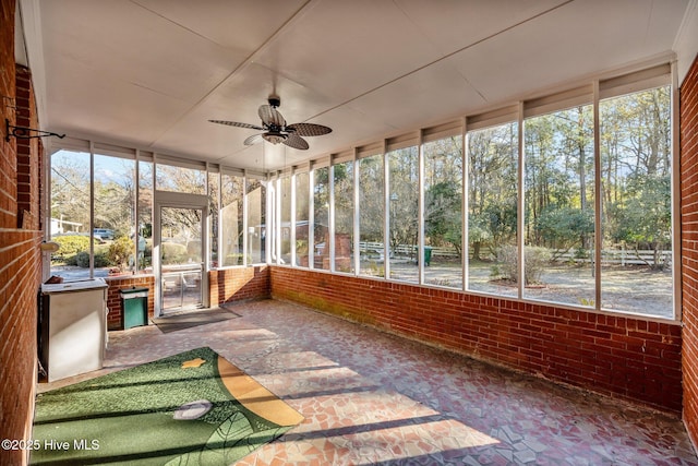 unfurnished sunroom featuring ceiling fan