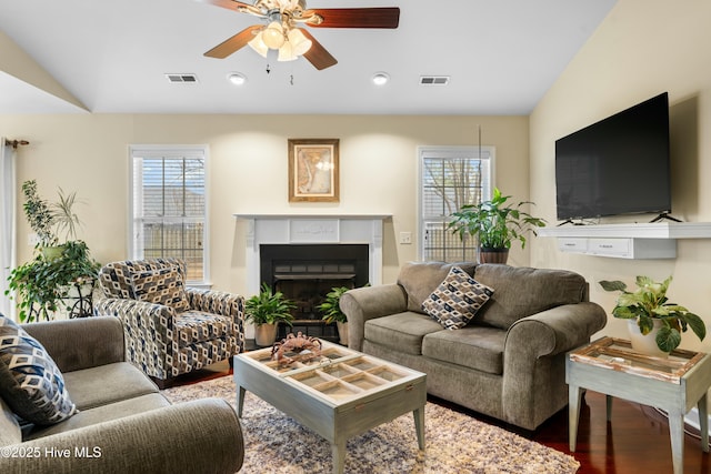 living room with ceiling fan, wood-type flooring, a healthy amount of sunlight, and vaulted ceiling