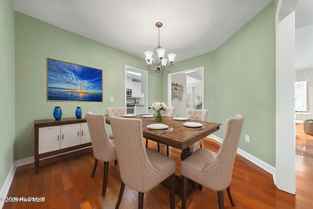 dining room with hardwood / wood-style floors and a chandelier