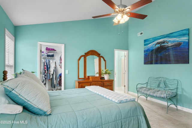 carpeted bedroom with vaulted ceiling, a spacious closet, ceiling fan, and a closet