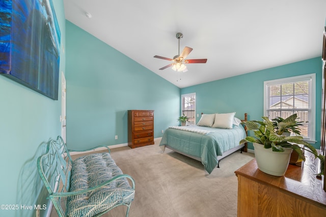 bedroom featuring multiple windows, vaulted ceiling, light colored carpet, and ceiling fan