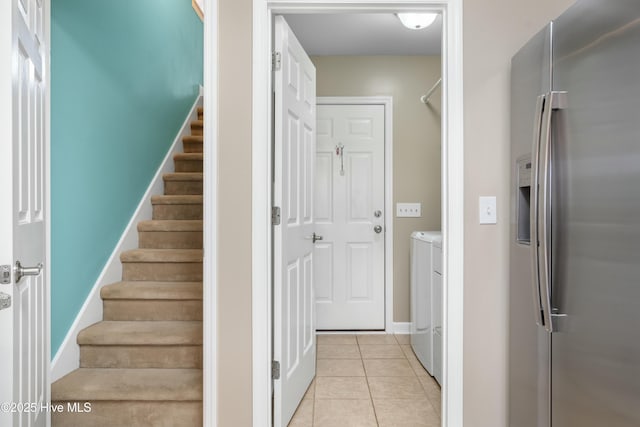 stairway featuring tile patterned floors and washer and clothes dryer